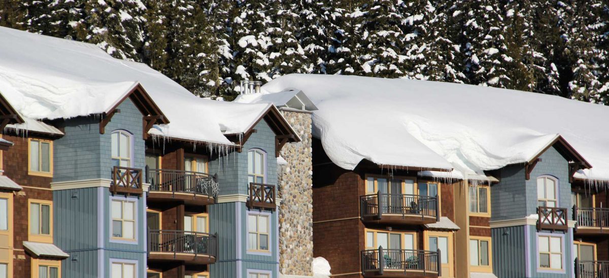 Snow-covered condo buildings at Mount Washington with icicles hanging from the rooftops.